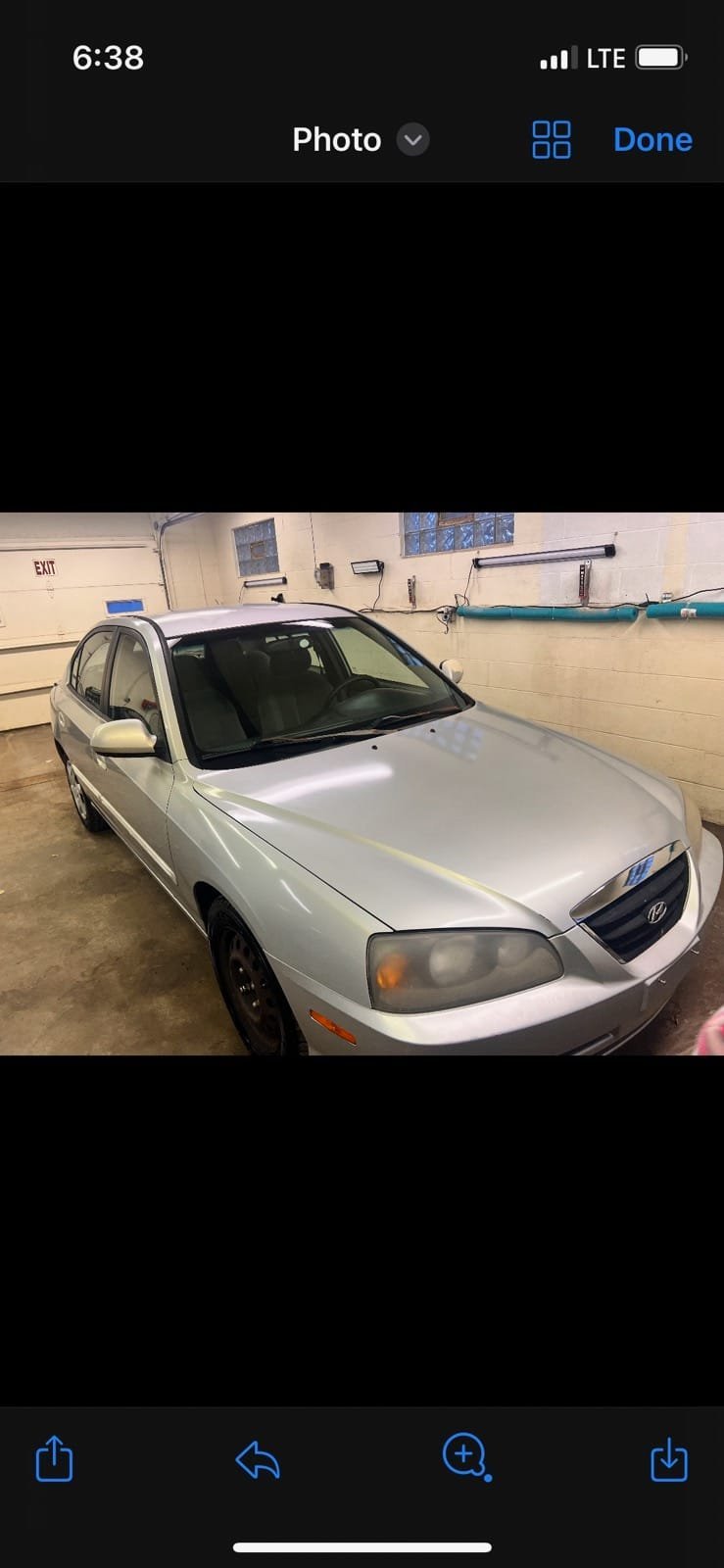 Silver Hyundai sedan parked in a garage with white walls and an exit sign visible